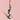 Decorative candle holder with a colorful candle on a pink background